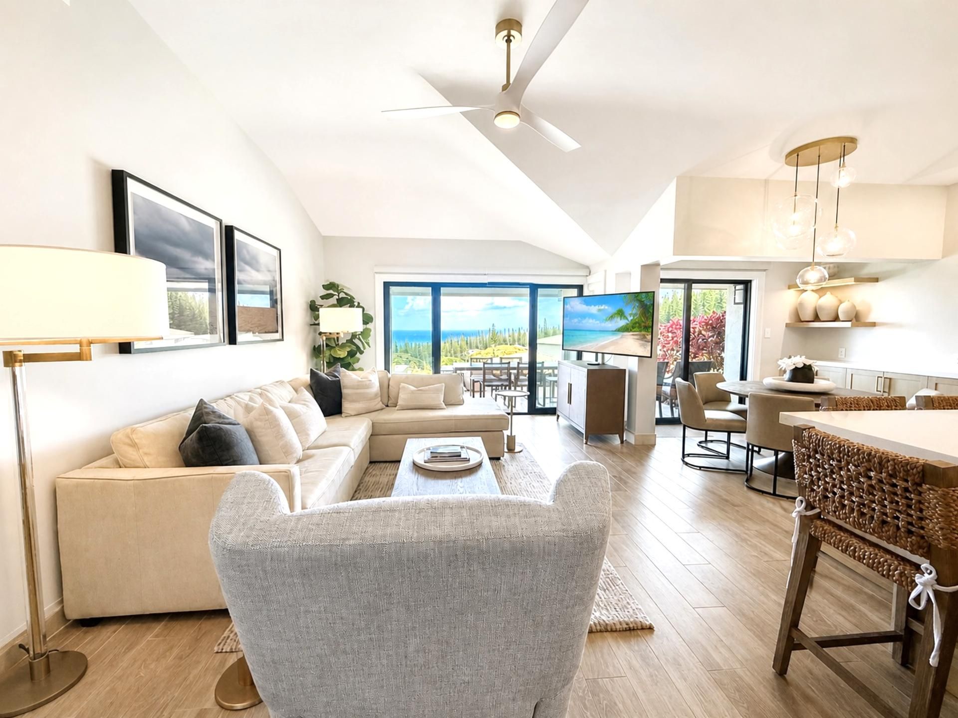 A modern living room with a sofa, armchair, and dining area.