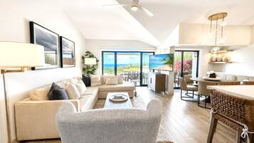 A modern living room with a sofa, armchair, and dining area.