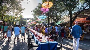 A street lined with tables set up for outdoor dining, surrounded by trees and buildings. - Delray Ocean Breeze (Delray Beach)