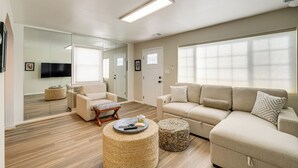 A spacious living room with a large sofa, a smaller sofa, a coffee table, and a TV mounted on the wall. - 2 Mi to Potomac Mills: Modern Home in Woodbridge (Woodbridge)