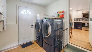 A laundry area with two front-loading washing machines, a drying rack, and a shelf with cleaning supplies. - 2 Mi to Potomac Mills: Modern Home in Woodbridge (Woodbridge)