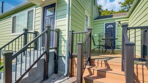 A green house with a wooden deck, a staircase, and a small outdoor table. - 2 Mi to Potomac Mills: Modern Home in Woodbridge (Woodbridge)