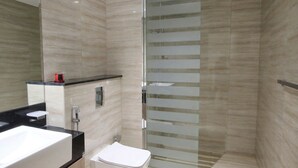 Une salle de bain moderne avec une douche à parois de verre, un lavabo et des toilettes.