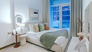 Une chambre à coucher moderne avec un lit, une table de chevet et une fenêtre avec des rideaux.