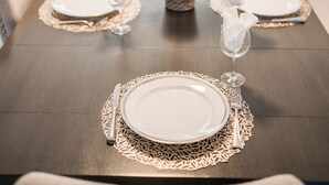 A dining table set with plates, cutlery, and a centerpiece. - Backyard Paradise in Chandler (Chandler)