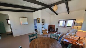 Amplia sala de estar con una mesa de comedor de madera y sillas, una chimenea y una zona de estar acogedora con un sofá y sillones.