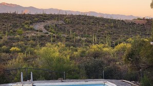 Una piscina con vista a un paisaje desértico y montañas al fondo.