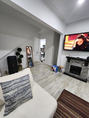 TV connectée, cheminée, livres, chaîne hi-fi