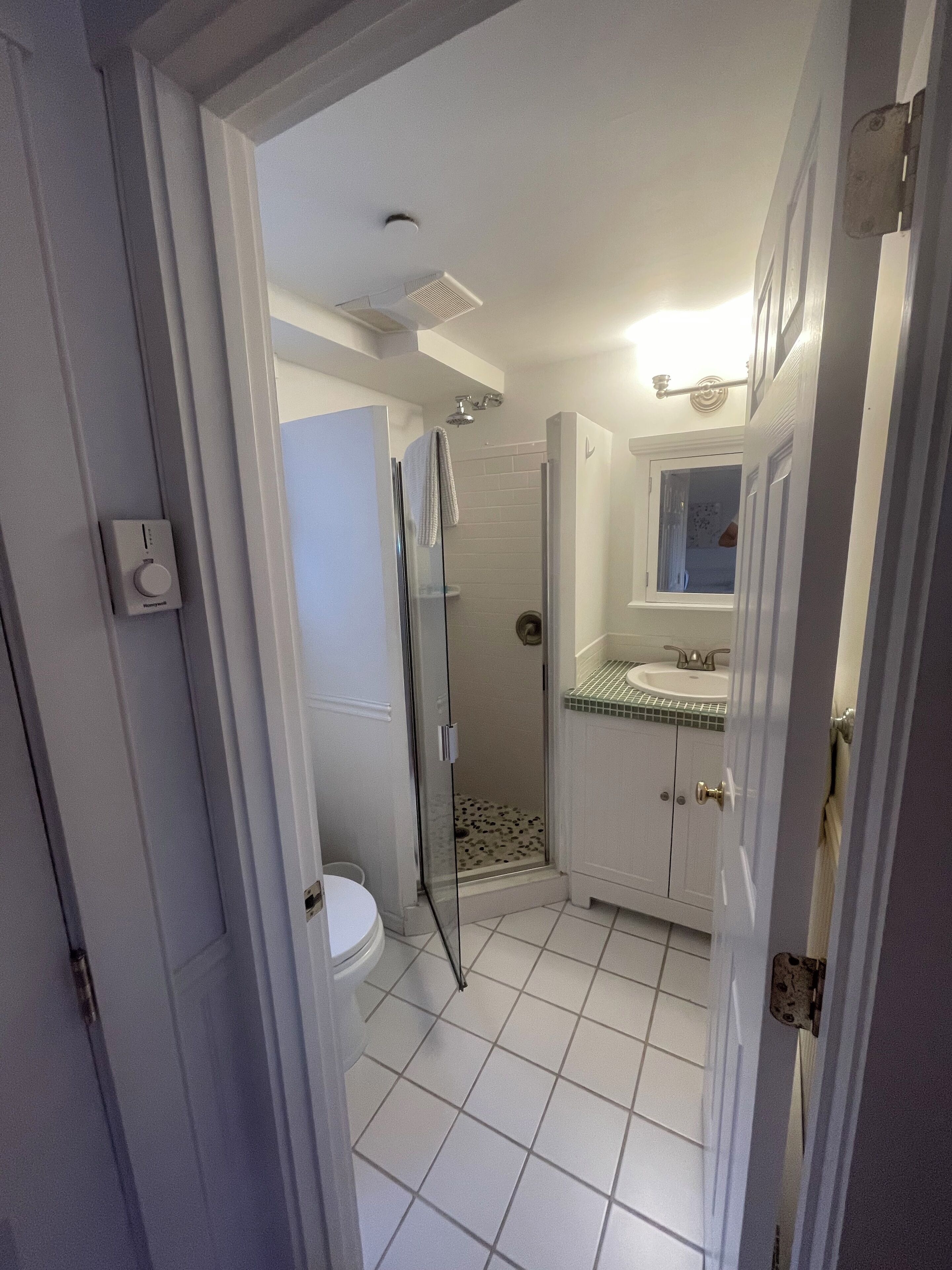 A bathroom with a shower, toilet, and sink.