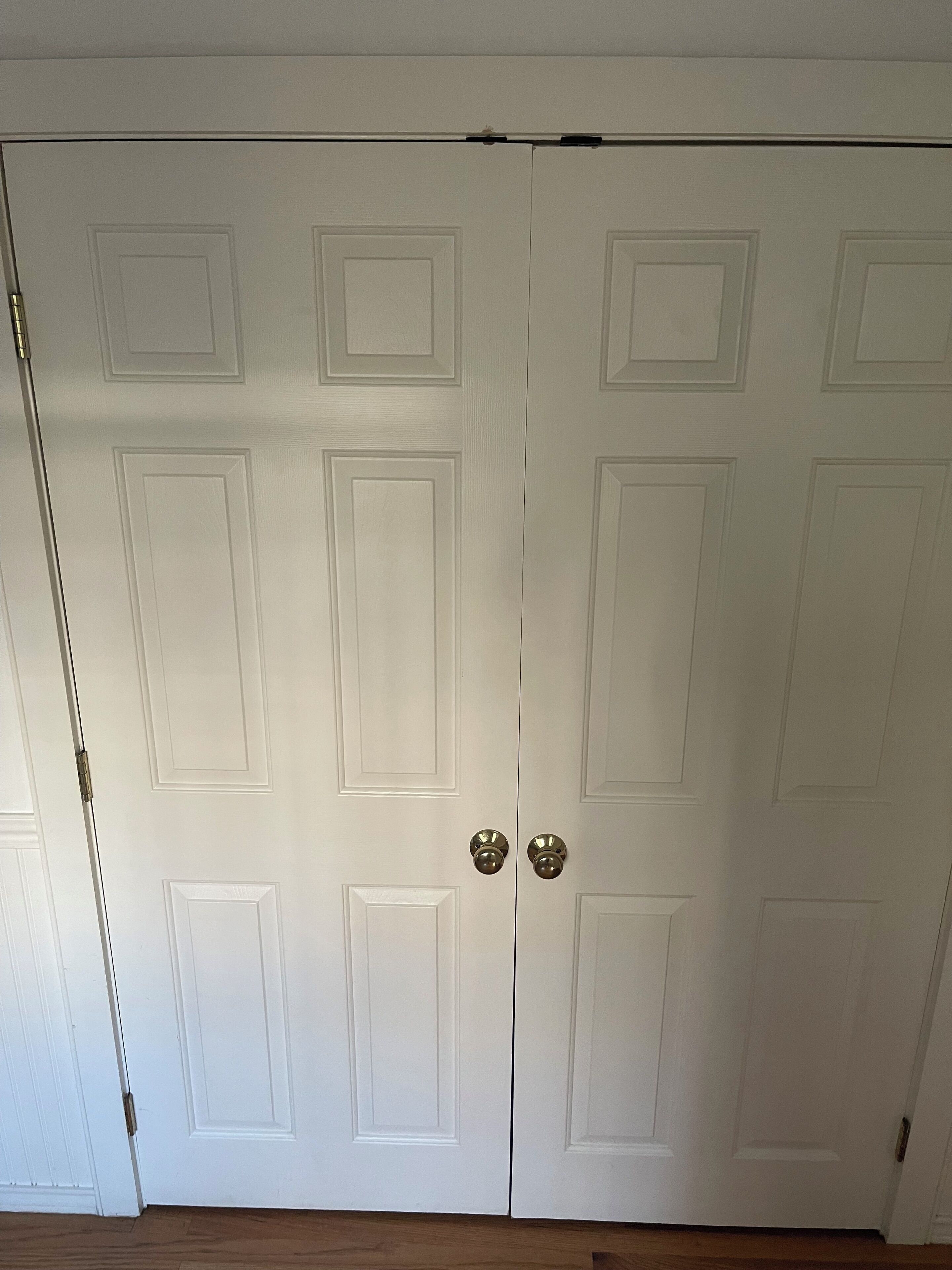 Una puerta blanca cerrada con manija y cerradura.