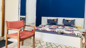A bedroom with a bed, a chair, and a door. - RESIDENCE EL HADJI (Dakar)