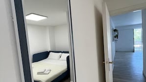 A modern hotel room with a large bed, a bedside table, and a mirror. - Porta Addaura (Palermo)