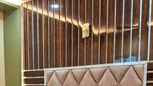Ein Bett mit einer gebügelten Kopfteil, zwei Kissen und Holzboden.