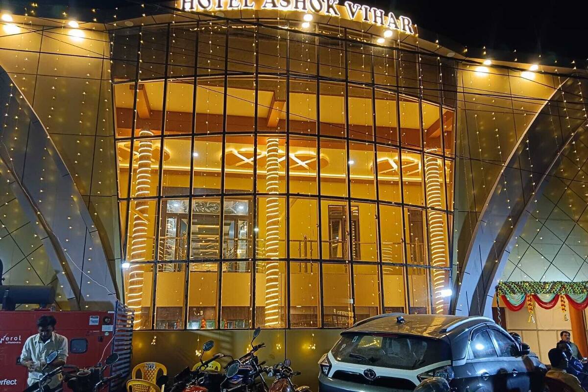 Un hotel con fachada de vidrio moderno y un letrero que dice "HOTEL ASHOK VIHAR".