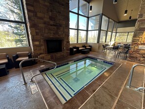 Relax by the pool with a fire crackling in the background, surrounded by comfortable seating areas.