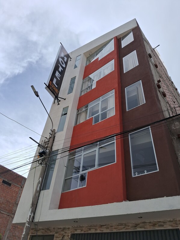 A multi-story building with a prominent sign for "El Varrey Suite". - Hotel EL Virrey Suite (Espinar)