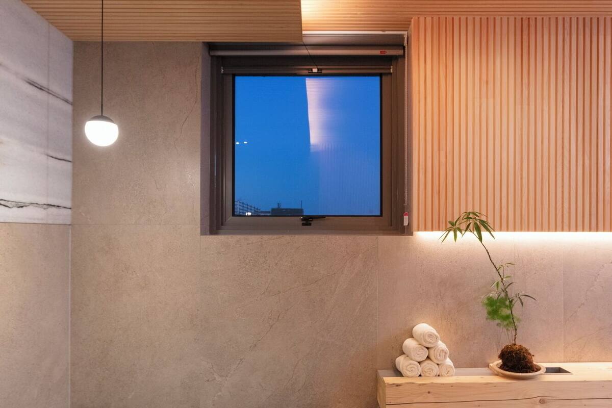 Een aparte badkuip en douche, een haardroger, handdoeken, shampoo