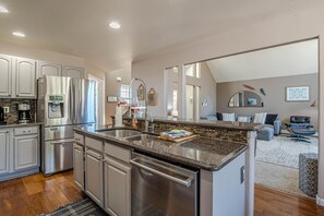 A modern kitchen with stainless steel appliances, a granite countertop, and a built-in dishwasher. - Casa Rimrock: Wake Up at CO Monument (Grand Junction)