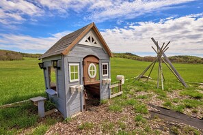 Eine kleine Holzhütte mit Satteldach, rundem Fenster und Briefkasten.