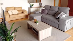 A modern living room with a grey sofa, beige sofa, and a wooden coffee table.