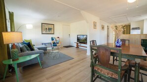 A living room with a sofa, a coffee table, a TV, and a dining table with chairs. - Charming Foothills Getaway – Near Yosemite & Gold Country (Sonora)