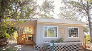 A single-story house with a covered porch, a small deck, and a fenced yard. - Charming Foothills Getaway – Near Yosemite & Gold Country (Sonora)
