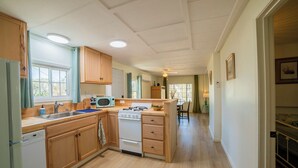 A spacious kitchen with wooden cabinets, a microwave, a stove, and a dishwasher. - Charming Foothills Getaway – Near Yosemite & Gold Country (Sonora)