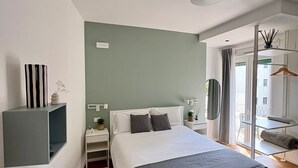 A modern bedroom with a large bed, bedside tables, a mirror, and a view of the outside. - Near Vatican Guest House Irnerio47 (Rome)