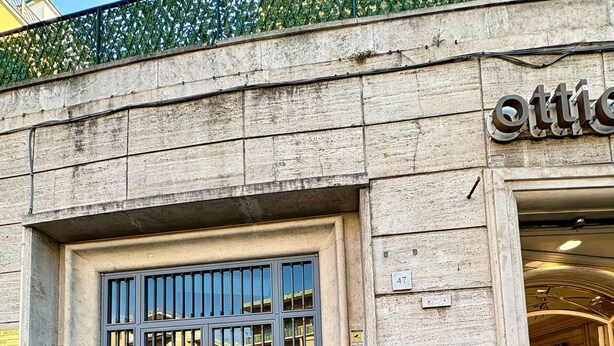 A building facade with a large metal-framed entrance door, a visible address sign, and a small window with a metal grate. - Near Vatican Guest House Irnerio47 (Rome)
