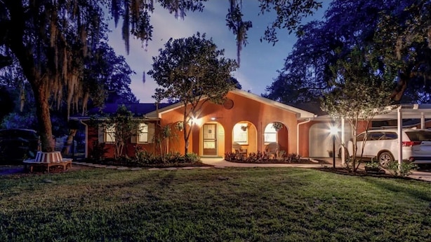 A two-story house with a well-maintained lawn and a driveway. - Lakeview Escape Kayaks (Inverness)