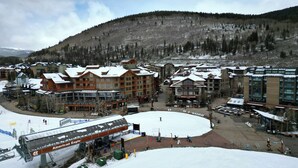 Une station de ski comprenant plusieurs bâtiments, notamment un chalet doté d'un télésiège et un grand bâtiment abritant un espace de location de matériel de ski.