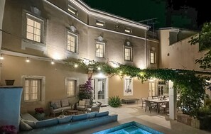 Relax by the pool in a serene courtyard with comfortable seating and a dining area.