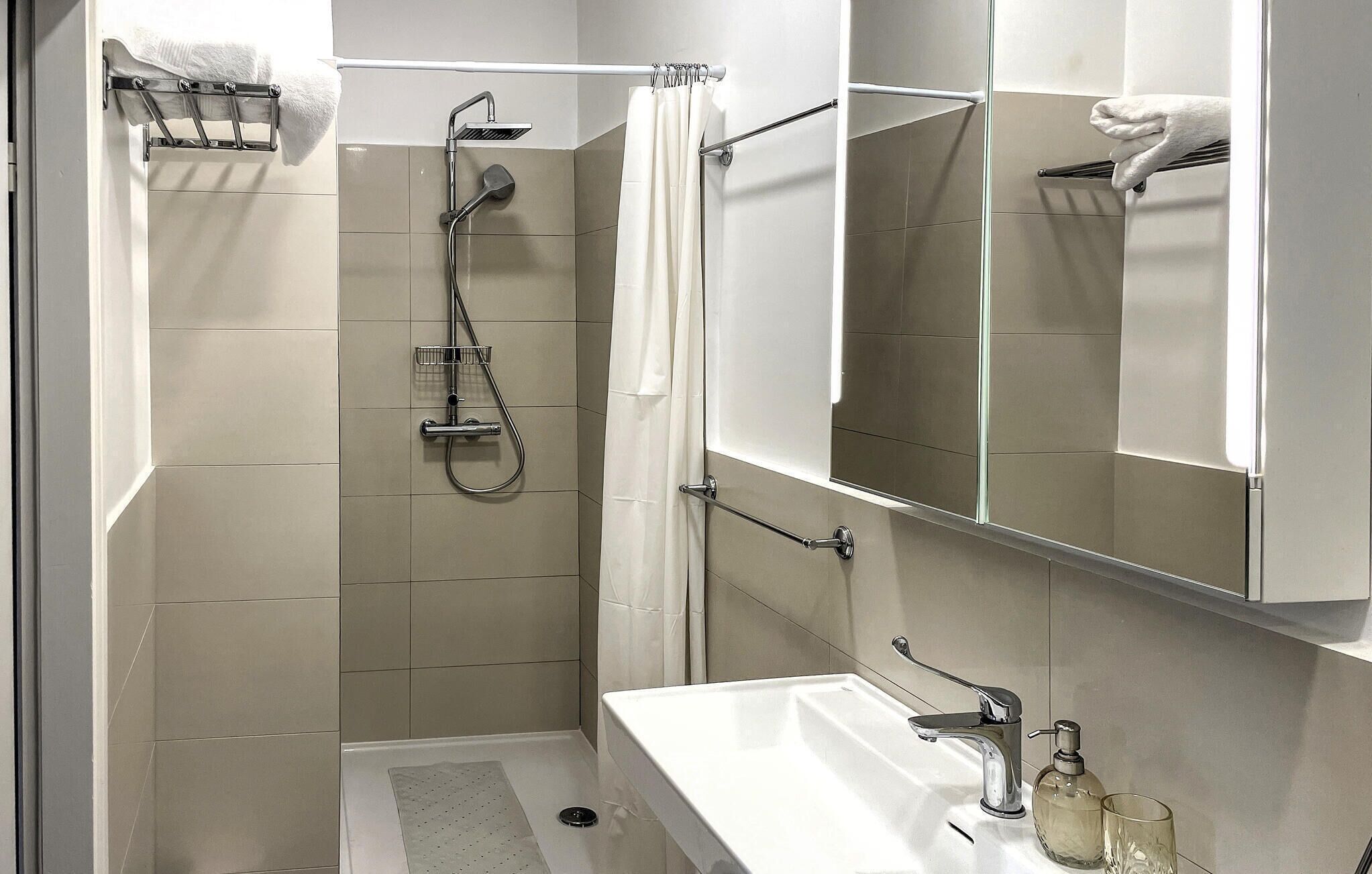 Une salle de bain moderne équipée d’une douche, de toilettes et d’un lavabo.