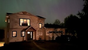 Une maison à deux étages avec un garage, un porche à l’avant et une allée.