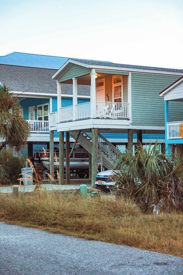 A two-story building with a balcony and a covered area.