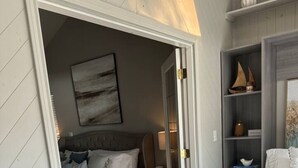 Un dormitorio con cama, mesita de noche, cómoda y armario.