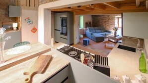 A modern kitchen with a built-in stove, wooden countertops, and a dining area with a table and chairs. - 4 bedroom nice home in Saint Etienne de Serre (Saint Etienne de Serre)