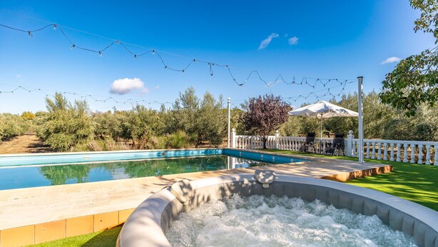 A swimming pool with a hot tub, surrounded by a white fence and string lights. - Amazing home in Setenil de las Bodegas (Setenil de las Bodegas)