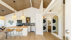 A modern kitchen with a central island, bar stools, and hanging pendant lights. - NEW!! Charming 1 bedroom bungalow in amazing Kailua-Kona Sept specials inquire!! (Kailua-Kona)