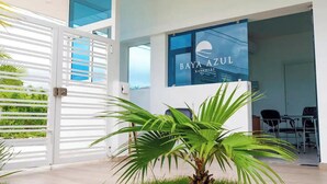 A modern building with a sign reading "BAYA AZUL" and a glass door. - Baya Azul Bayahibe - Penthouse 401 (San Rafael del Yuma)