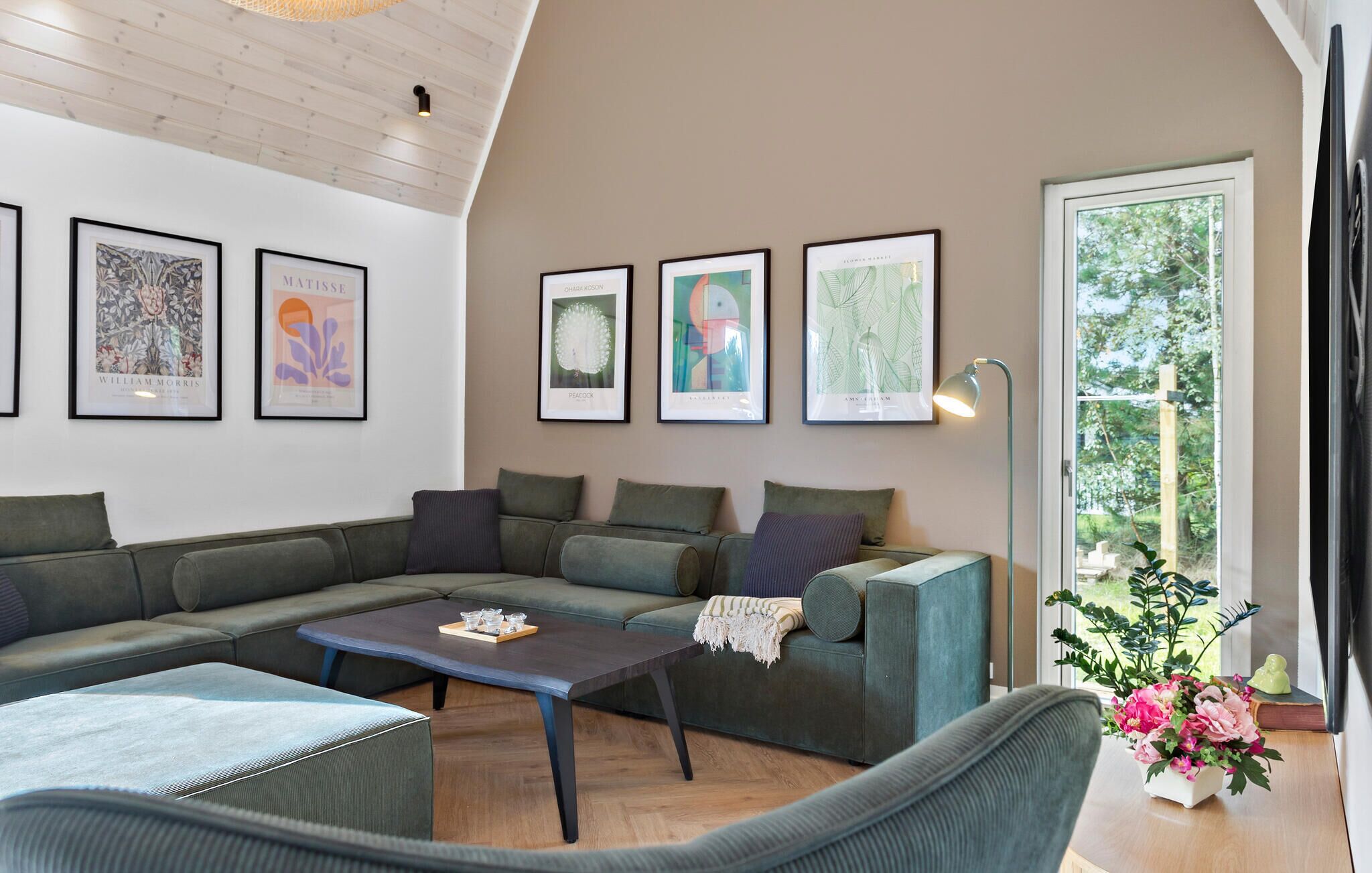 A modern living room with a sectional sofa, a coffee table, and framed artwork on the wall.