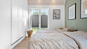 Un dormitorio con cama, ventana y puerta.