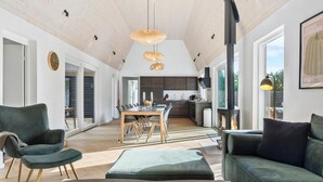Un espacio habitable amplio con techo alto, una mesa de comedor y una zona de estar acogedora.