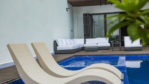 A pool area with two lounge chairs and a sofa. - Luxury seaside villa (Ngaparou)