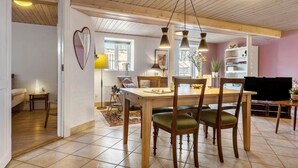 A dining area with a wooden table and chairs, a bookshelf, and a television. - Awesome home in Randers SV with WiFi (Randers SV)