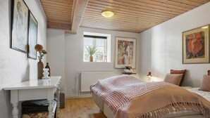 A bedroom with a bed, a dresser, a radiator, a window, and artwork on the walls. - Awesome home in Randers SV with WiFi (Randers SV)