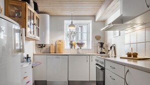 A modern kitchen with white cabinetry, a built-in dishwasher, a coffee machine, and a window with a view. - Awesome home in Randers SV with WiFi (Randers SV)