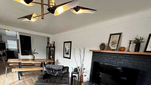 A modern living room with a fireplace, a leather sofa, a coffee table, and a TV. - Newly Renovated Pad Near DT BZN! (Bozeman)