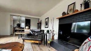 A modern living room with a leather sofa, a wooden coffee table, a fireplace, and a TV. - Newly Renovated Pad Near DT BZN! (Bozeman)