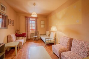 Ein gemütliches Zimmer mit einem Bett, einer Couch, einem Tisch und einem Sessel.